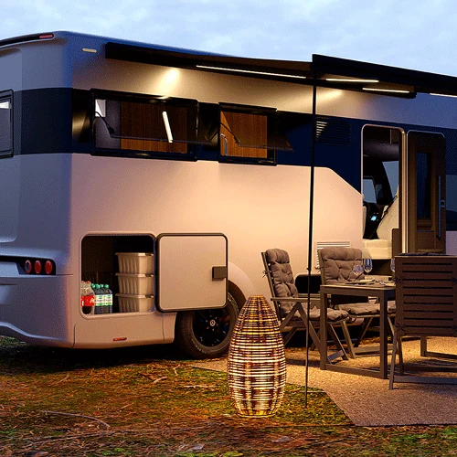 HIP Campers 4Family at dusk with open garage doors and an outdoor table and chairs